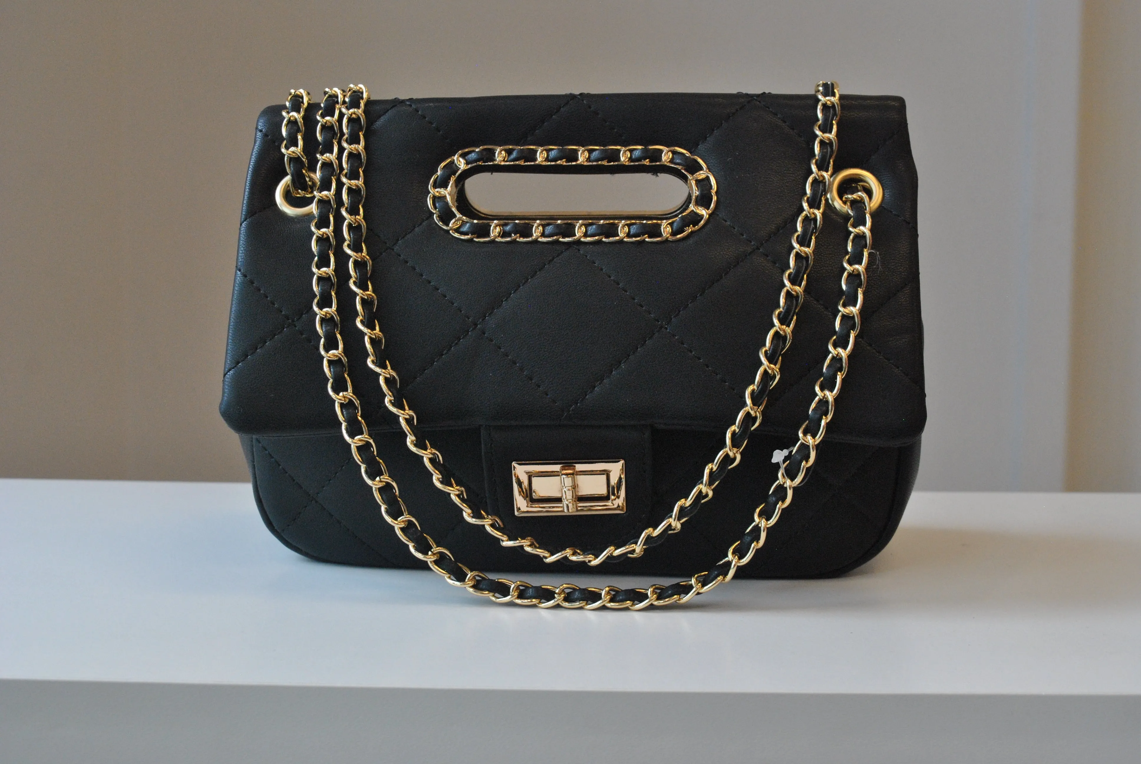 BLACK GUILTED HANDBAG WITH CUTOFF  HANDLE AND GOLD CHAIN