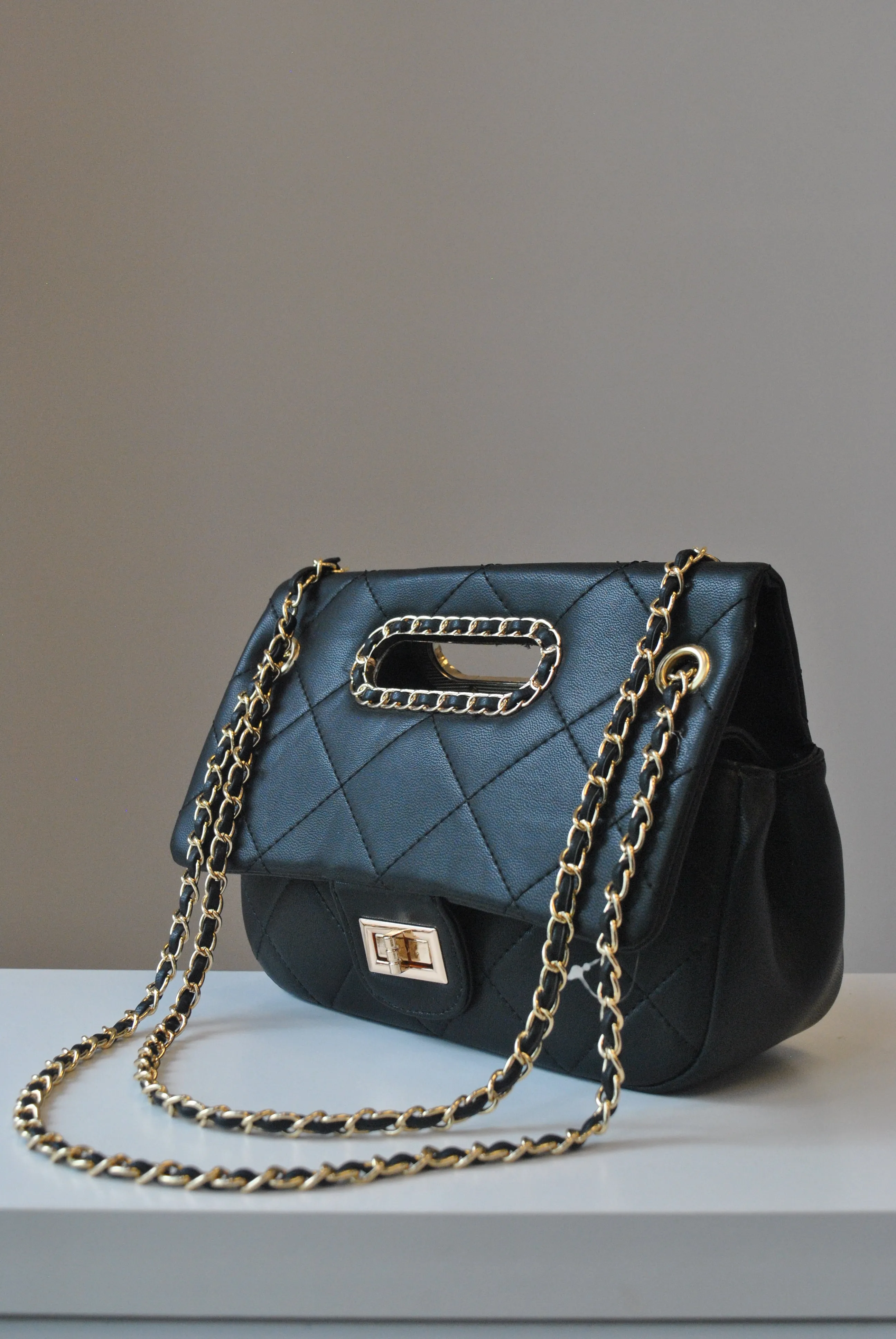 BLACK GUILTED HANDBAG WITH CUTOFF  HANDLE AND GOLD CHAIN