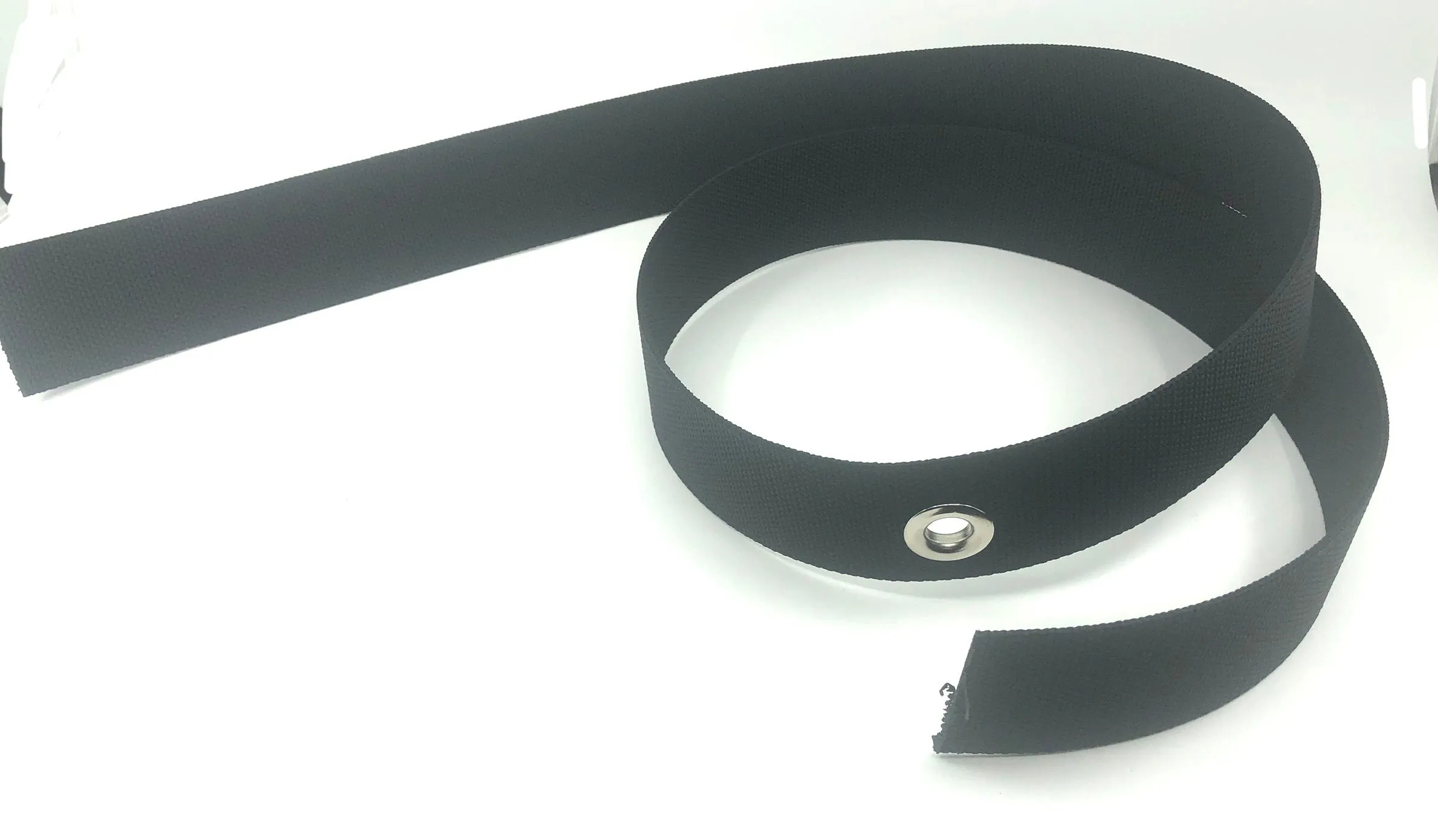 Harness webbing with a grommet in the middle