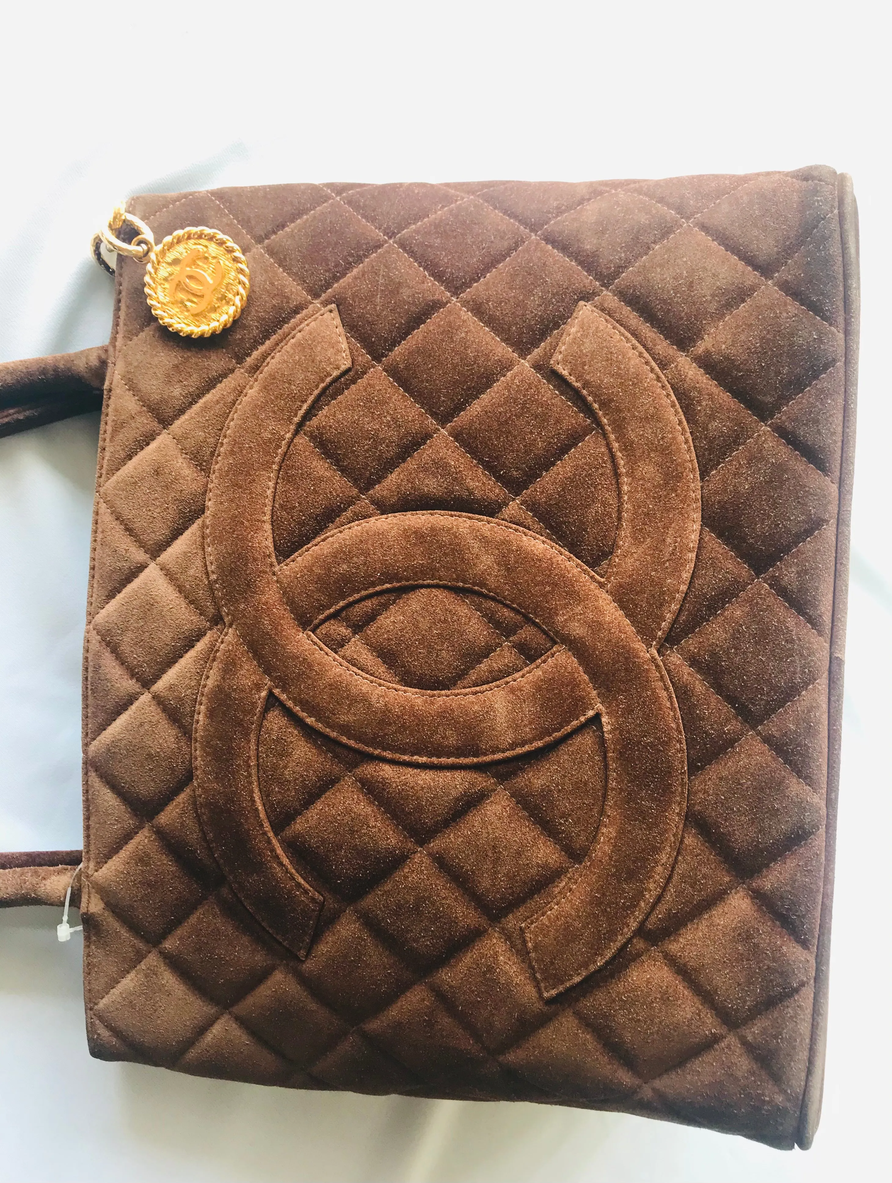 Vintage CHANEL brown suede classic tote bag with large CC mark and golden CC medal charm to the zipper. Classic purse for daily use.