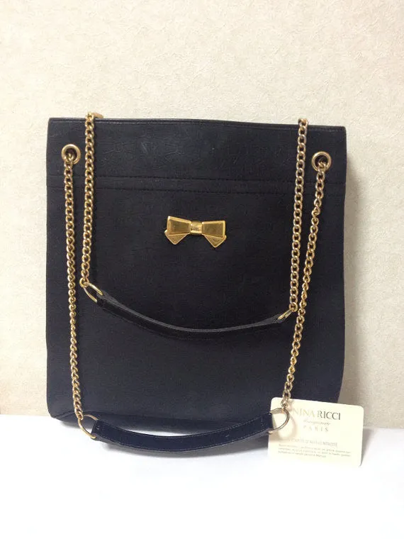 Vintage Nina Ricci black tote bag with golden chain straps with golden logo bow, ribbon shape motif. Perfect daily purse