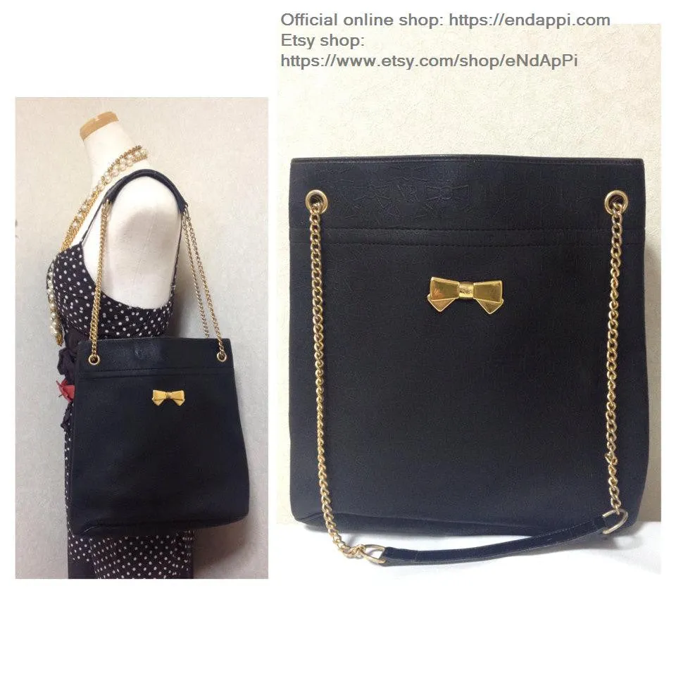 Vintage Nina Ricci black tote bag with golden chain straps with golden logo bow, ribbon shape motif. Perfect daily purse